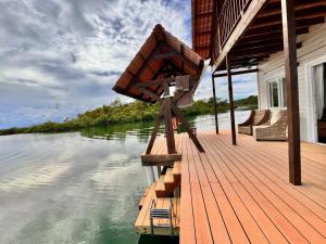 a wooden deck on a house on a river at Six Pillars Resort in Bocas Town +10 photos