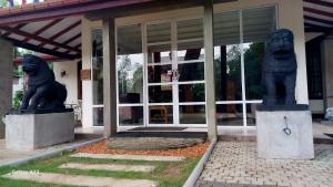 two statues of lions in front of a building at Sadula Holiday Resort in Anuradhapura