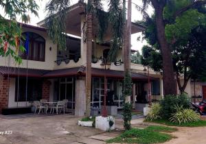 a building with a palm tree in front of it at Sadula Holiday Resort in Anuradhapura