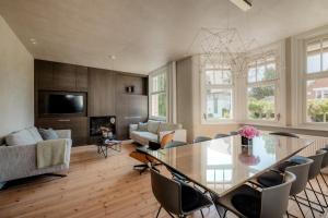 a dining room and living room with a glass table and chairs at Villa-Sabbia in Koksijde