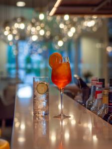 un drink seduto al bancone del bar con un bicchiere di Hilton Garden Inn Munich Messe a Feldkirchen