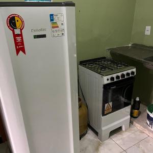 a white refrigerator next to a stove in a kitchen at Casa do Will in Ananindeua