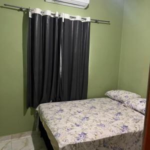 a bedroom with a bed with a black curtain at Casa do Will in Ananindeua