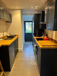 a kitchen with black cabinets and a tile floor at Folly Field in Haworth