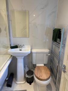a bathroom with a toilet and a sink and a mirror at Folly Field in Haworth +14 photos