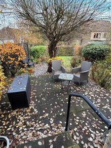 a patio with two chairs and a table and a tv at Folly Field in Haworth
