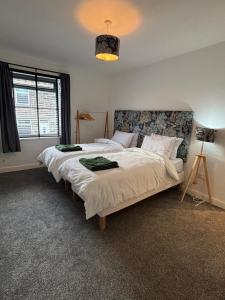 a bedroom with two beds and a chandelier at Folly Field in Haworth