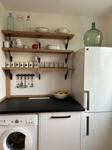 a kitchen with a white refrigerator and a washing machine at Zelený byt u Bořího lesa in Břeclav