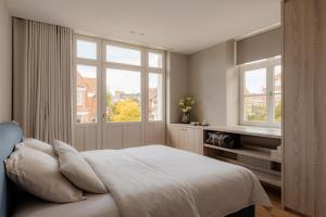 a bedroom with a bed and two windows at Villa-Sabbia in Koksijde +110 photos