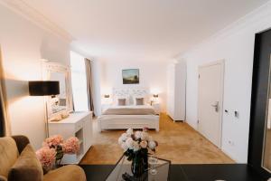 una camera da letto bianca con un letto e un divano di Golden Hotel a Pristina