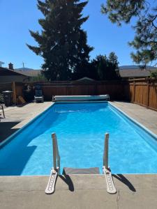 a swimming pool with two lawn chairs next to it at Bright poolside walkout two bedroom basement suite in the Okanagan in Penticton
