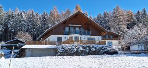 a large house in the snow with trees at Apartmenthaus Kammblick in Gröbming
