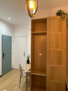 a room with a table and a wooden cabinet at Studio Ô terrasses de Virieu in Pélussin