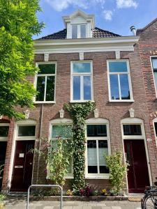 a red brick house with windows and ivy at Bed & Breakfast Anna in Groningen