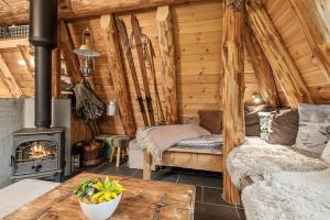 een kamer met een houtkachel in een hut bij Unique Hobbit Cabin By Hallingskarvet in Hovet