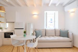 a white living room with a white couch and a table at Galaxidaki στην Πλατεία in Galaxidi