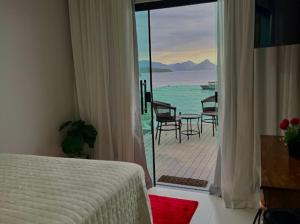 a bedroom with a bed and a view of the ocean at Recanto do Leste in Angra dos Reis