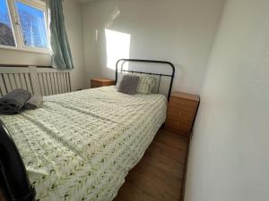 een slaapkamer met een bed en een raam bij 4-Bed Barnwell Retreat- Sleeps10 Garden & Parking in Stevenage