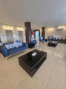 a large living room with blue couches and a table at Seven Days Hotel in Irbid