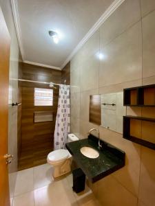 a bathroom with a toilet and a sink in it at Suítes Itapoã in Ubatuba +31 photos