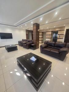 a living room with couches and a flat screen tv at Seven Days Hotel in Irbid