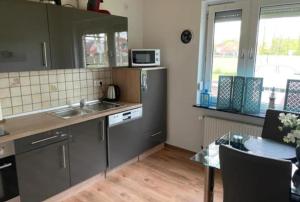 a kitchen with a sink and a refrigerator and a table at Ferienhaus Seestern in Dornum