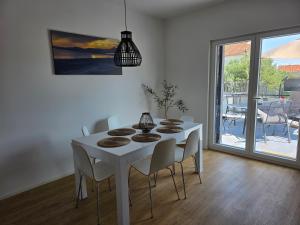 a white dining room with a white table and chairs at Ana i Marko in Vodice