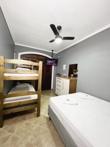 a bedroom with two bunk beds and a ceiling fan at Hostel Anprado #5 Kit café incluso, Próx-Aeroporto de Guarulhos in Guarulhos