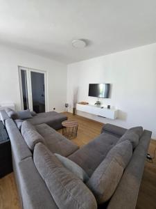 a living room with a large couch and a flat screen tv at Ana i Marko in Vodice