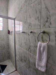 una doccia con un asciugamano bianco appeso a un muro di Pousada Imperatriz a Aparecida