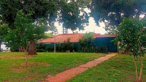 a house with a blue wall and some trees at Green Park Urbarí in Santa Cruz de la Sierra