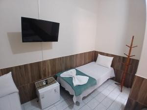 una camera da letto con un letto e una TV a schermo piatto di Pousada Imperatriz a Aparecida