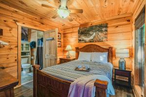 a bedroom with a bed and a ceiling fan at Goonies Cove - Spacious 4BR Cabin Arcade, Pool Table & Hot Tub! in Sevierville +91 photos