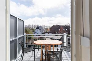 a patio with a table and chairs on a balcony at Haus Strandkrabbe, Seehund in Döse +18 photos