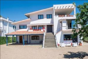 a large white house with stairs in front of it at Verde Blu Scirocco Lake Front Apartment Trevignano Romano in Rome