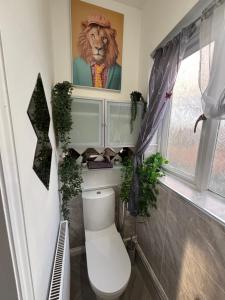 a bathroom with a lion picture above a toilet at Stylish modern Cottage, Kidderminster in Kidderminster +26 photos