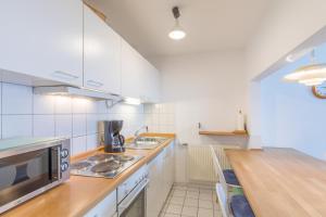a kitchen with white appliances and a wooden counter top at Haus Stranddüne, Whg 6 in Cuxhaven