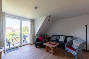 a living room with a couch and a table and a balcony at Haus Stranddüne, Whg 6 in Cuxhaven