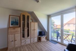 a living room with a large sliding glass door at Haus Stranddüne, Whg 6 in Cuxhaven +12 photos