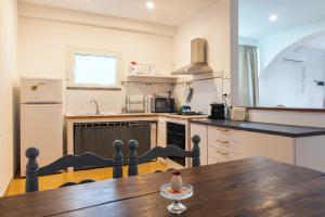 a kitchen with a wooden table and a kitchen with a refrigerator at Verde Blu Scirocco Lake Front Apartment Trevignano Romano in Rome +11 photos