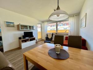 a living room with a wooden table and a living room with a living room at Haus Vogelsand, App 324 in Cuxhaven