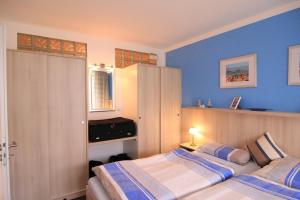two beds in a bedroom with blue walls at Haus Vogelsand, App 324 in Cuxhaven +23 photos