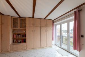 a kitchen with wooden cabinets and a large window at Am Grooten Steen, Whg 19 in Duhnen