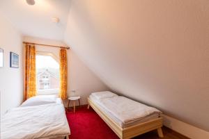 two beds in a small room with a window at Am Grooten Steen, Whg 19 in Duhnen