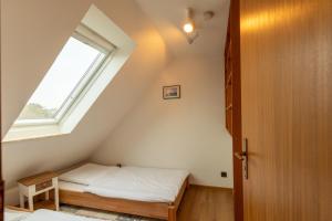 a attic bedroom with a bed and a window at Am Grooten Steen, Whg 19 in Duhnen