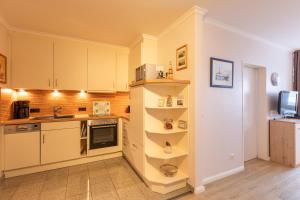 a kitchen with white cabinets and a counter top at Haus Knechtsand, Whg 433 in Cuxhaven