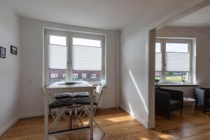 a living room with a table and two windows at Wohnung Deichbude in Cuxhaven