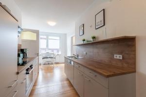 a kitchen with white cabinets and a wooden counter top at Wohnung Deichbude in Cuxhaven