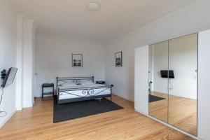 a white room with a bed and a glass wall at Wohnung Deichbude in Cuxhaven +9 photos