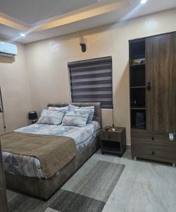 una camera da letto con un letto grande e un armadio in legno di Smartcribs 1 Bedroom Solar Powered Apartment, GRA a Port Harcourt